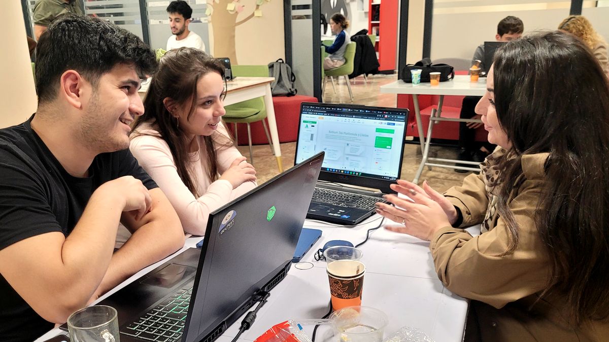Üç genç dizüstü başında çözümü tartışıyor, gülümseme