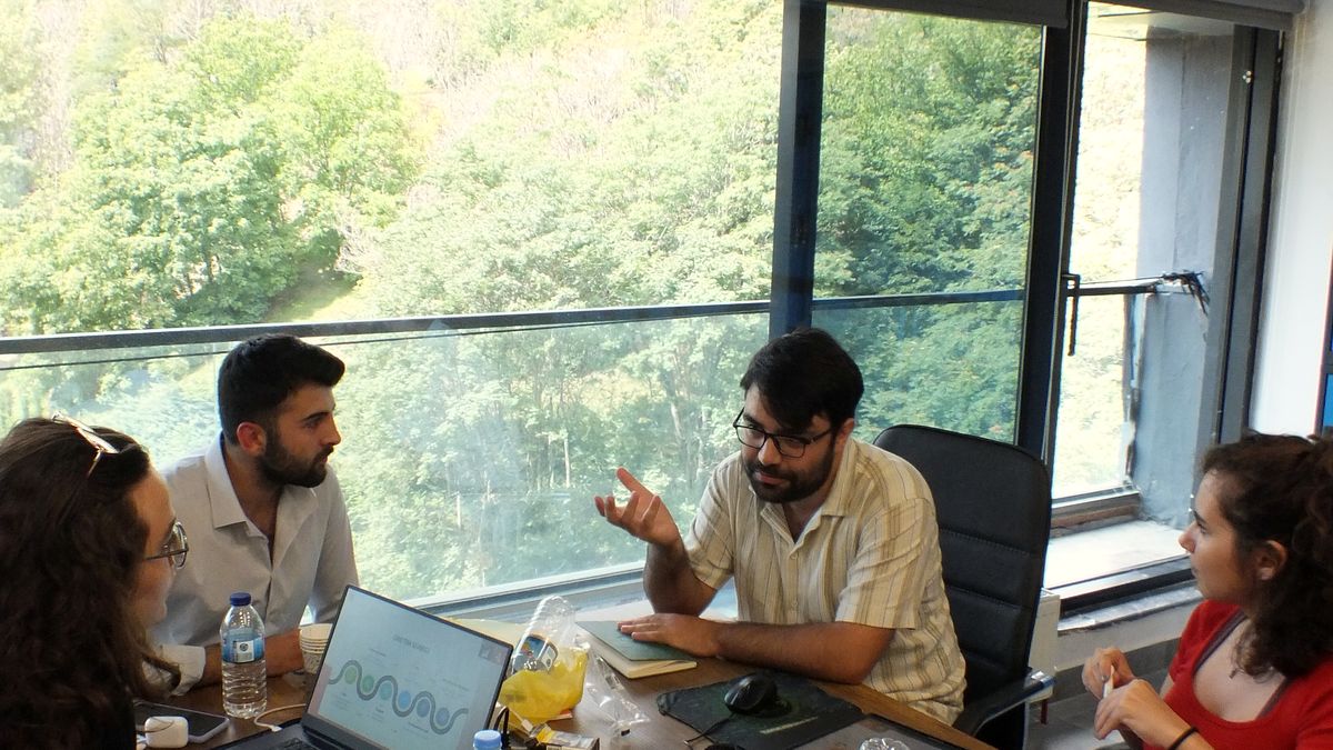 Mentor pencere önünde takıma dizüstündeki süreci anlatıyor