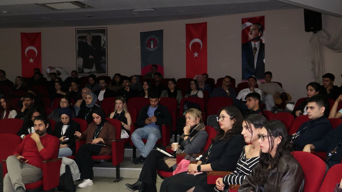 Konferans salonunu dolduran genç katılımcılar dinliyor