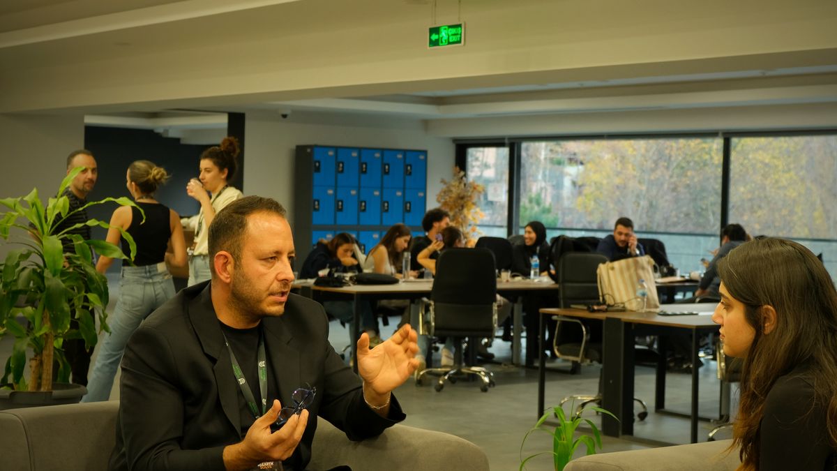Mentor kanepede genç katılımcıyla birebir görüşüyor, açık ofis